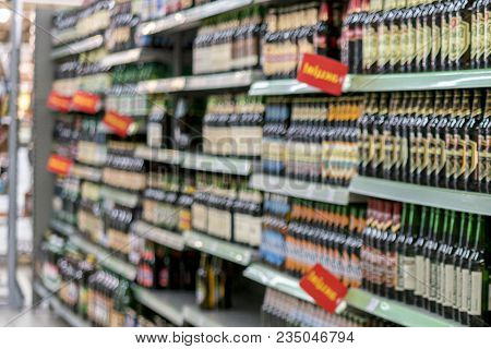 Different Types Of Beer On The Shelves In The Supermarket. Blurry.