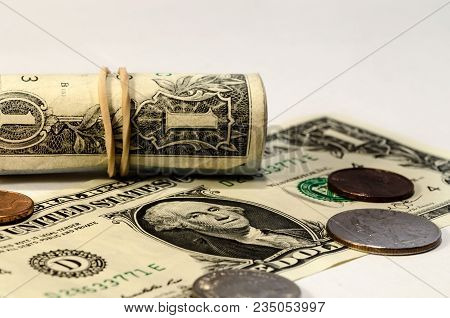 Still Life With A Dollar Bill Rolls Over A White Background. Symbol Of Wealth