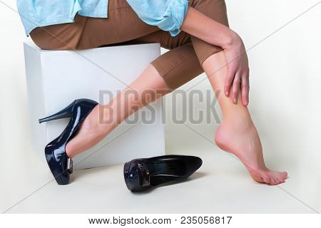 Cropped Image Of Woman In High Heels Massaging Her Tired Legs. Varicose Veins Concept. Painful Varic
