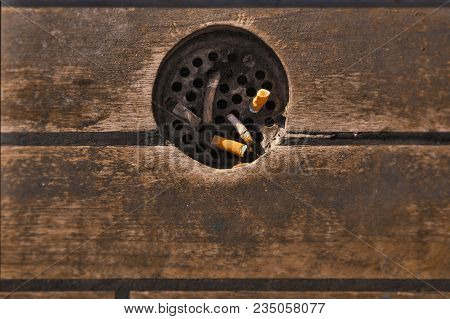 Street Trash With Ashtray And Cigarette Butts Against The Wooden Floor. Ash-pot.
