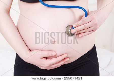 Image Of Pregnant Woman Touching Her Big Belly. Close Up. Motherhood, Pregnancy, People And Expectat