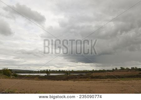Heavy Grey Clouds In The Cold Autumn Sky Over Rivers, Fields, Forests And Mountains