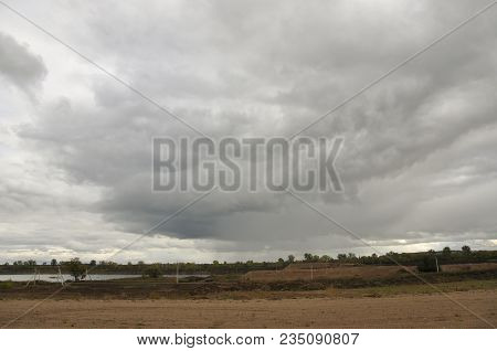 Heavy Grey Clouds In The Cold Autumn Sky Over Rivers, Fields, Forests And Mountains