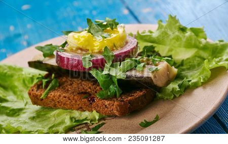 Sol Over Gudhjem - Danish Dish, An Open Sandwich With Rugbrod, Smoked Herring, Chives And A Raw Egg 