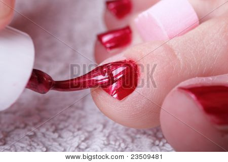 Piedi femminili rosso lucido chiodi