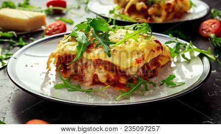 Homemade Lasagna With Minced Beef Bolognese And Bechamel Sauce Topped Wild Arugula, Parmesan Cheese.