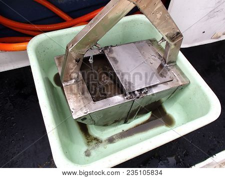 Benthic grab with the sample inside in the basin