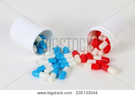 Different Colorful Capsules Are Falling Out Of Small Plastic Tins In The Studio