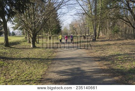 Three People , Young Women And Men Running Or Jogging On Publick Park Road In Prague Hostivar, Early