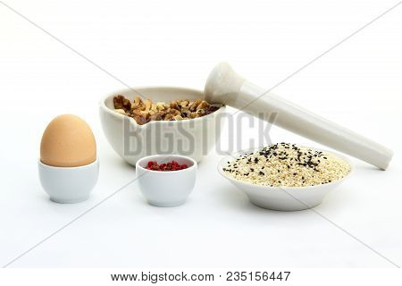 Keto Crackers Recipe Ingredients. Walnuts In Mortar For Grinding, Egg, Black And White Sesame Seeds,