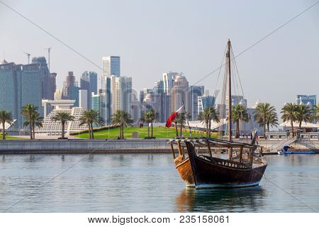 DOHA, QATAR - April 7, 2018: A traditional sailing dhow, complete with mast, moored  in the Museum Lagoon in Doha, Qatar