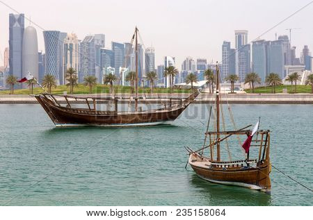 DOHA, QATAR - April 5, 2018: Dhows anchored in the Museum lagoon with the city's distinctive skyline behind