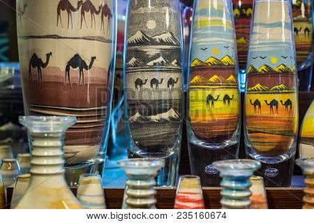 Close up of handmade sand art in glass bottles available in a street shop in Dubai, UAE.