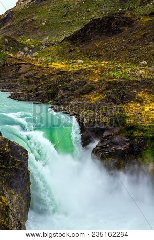  Southern Province of Chile. The famous picturesque Torres del Paine. A powerful rumbling waterfall Salto Grande. Concept of exotic and ecological tourism