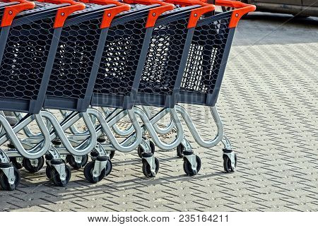 Row Of Trolleys From A Supermarket In The Street On The Sidewalk