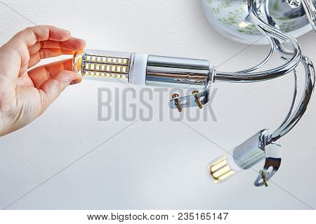 Installation Of Domestic Led Lamps Corn Type, In Lampholder Of Ceiling Light, Female Hand Is Screwin
