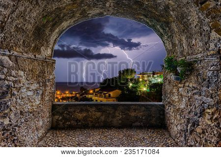 Scenic Rock Arch Balcony Overlooking A Lightning Storm Over The Sea