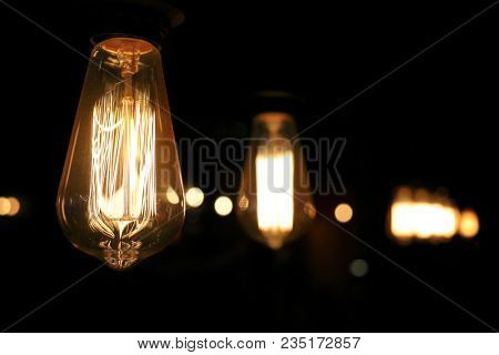 Close-up hanging retro lamp of Edison in the row of included lamp in the dark