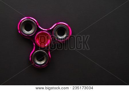 Fidget Finger Metal Spinner, Anxiety Relief Toy On Black Background, Copyspace. Concept Relieving St