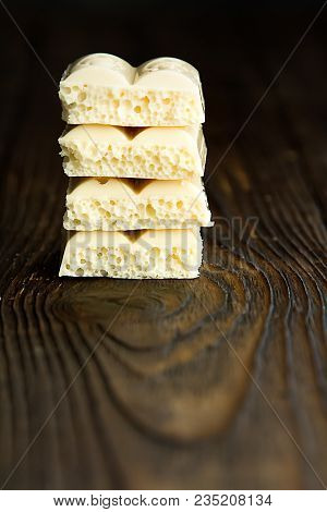 Pyramid Of White Porous Chocolate On A Wooden Vintage Old Background In The Style Of Moodle