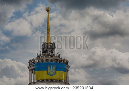 Ukrainian Flag On The Front Of The Building With The Star, Which Was Built In The Times Of The Ussr.