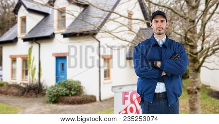Security guard with arms crossed standing on road against house