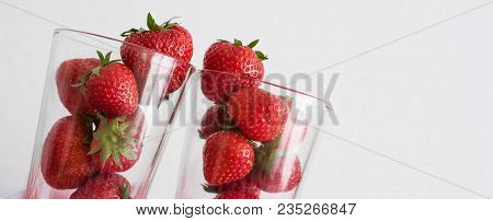 Fresh Red Strawberries Piled In Two Glasses On White Background.