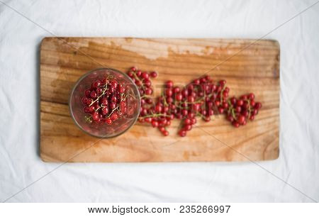 Red Currant In The Glass On Wooden Background. View From Above. Seasonal Fruit.