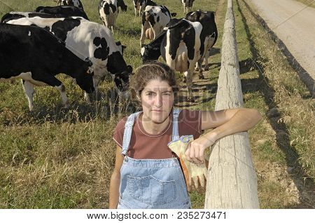 Portrait Of A Farmer With Her Cows In The Field