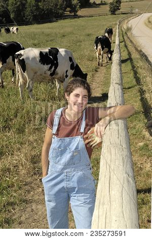 Portrait Of A Farmer With Her Cows In The Field