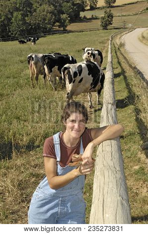 Portrait Of A Farmer With Her Cows In The Field