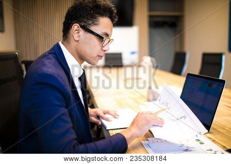 Man In Glasses Successful Economist Or Financier Working With Financial Graphics And Laptop Computer