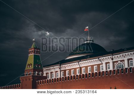 Night Shot: Kremlin Moscow Dome Of Senate Building, A Red Kremlin Wall, Flag Of Russia With The Embl