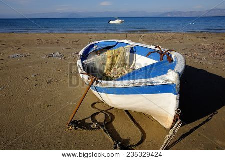 Lonely Fisherboat With Net And  Anachor At The Coast Of Kavos In Corfu, Greece