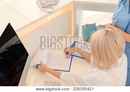 Female receptionist with trainee in hospital