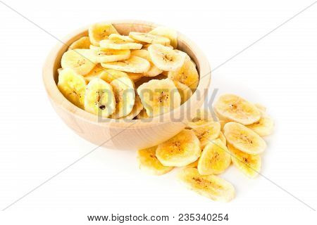 Heap Of Dried Banana Chips Snack In Wooden Bowl Over White Background