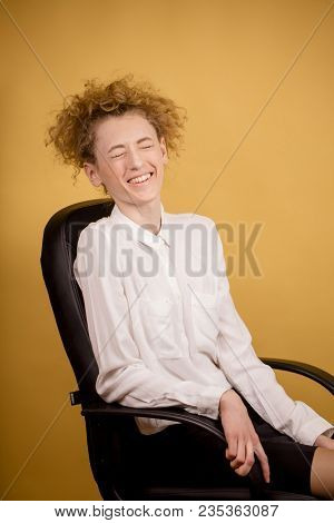Side View Closeup Photo Of Gigling Office Worker Sitting On The Chair. Laugh Aloud. Chortle