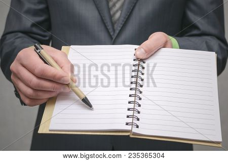 Businessman Holds In Hand A Note Pad With Pen. To Do List Template. Goals Or Business Tricks. Busine