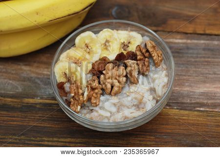 Top View Of A Granola Bowl, Muesli With Oats, Nuts And Dried Fruit On Wooden Table. Healthy Breakfas