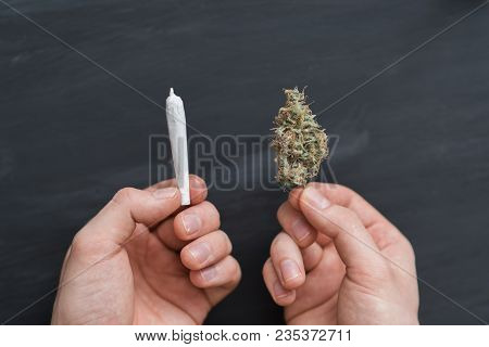 Hand Of Man Rolled Joint Buds Of Marijuana, Unrolled Weed On A White Background Top View Close Comfo