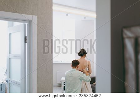 Morning Preparation Newlyweds For The Wedding. A Young Guy In A Light Shirt Fastens Exquisite Weddin
