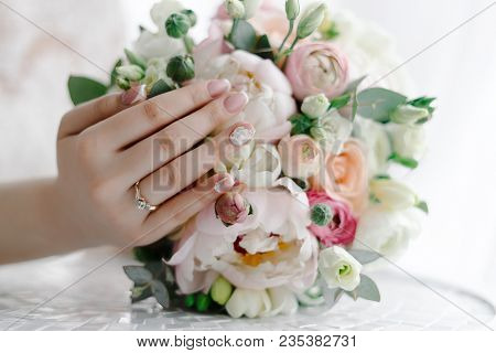 Tender Bride Touching Wedding Bouquet Showing Elegant White Wedding Manicure On The Background Of We
