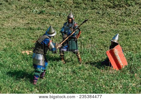 Luh, Russia - August 27, 2016: Reconstruction Of Medieval Battle Of Knights In Armor And Weapons At 