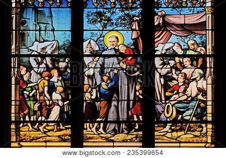 PARIS, FRANCE - JANUARY 04: Saint Vincent de Paul gathering with the Daughters of Charity abandoned children, stained glass window in Saint Severin church in Paris, France on January 04, 2018.