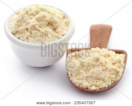 Gram Flour In Bowl And Wooden Scoop Over White Background