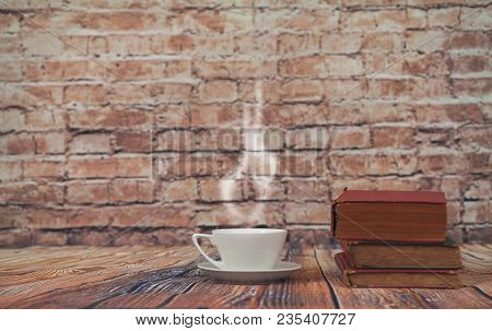 Coffee Cup On Old Book Set Up On Wood Table And Old Brick Wall.