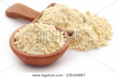 Gram Flour In Wooden Scoop Over White Background