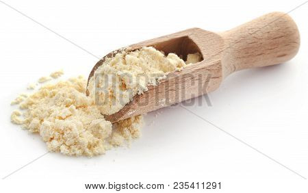 Gram Flour In A Wooden Scoop Over White Background