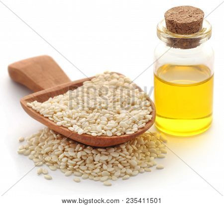 Peeled Sesame Seeds With Oil In Bottle Over White Background