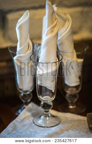 Wine Glasses On A Wooden Table With White Napkings